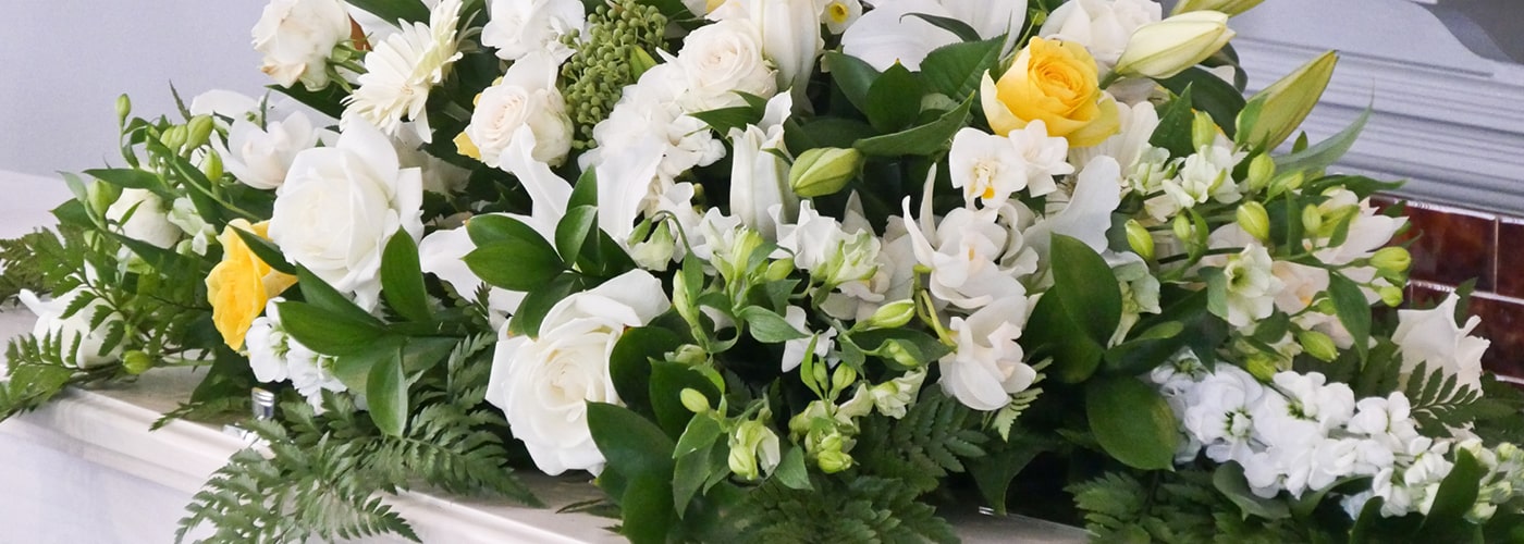 A white lily and rose funeral spray